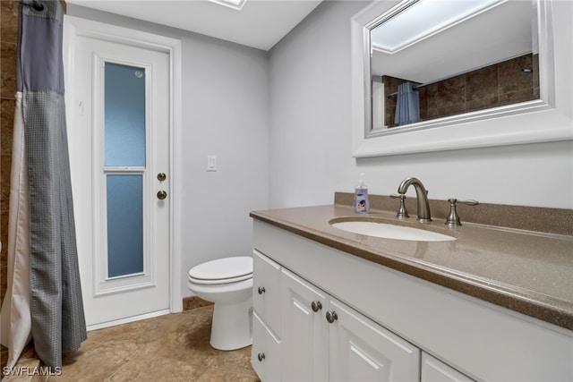 bathroom with vanity, toilet, and walk in shower