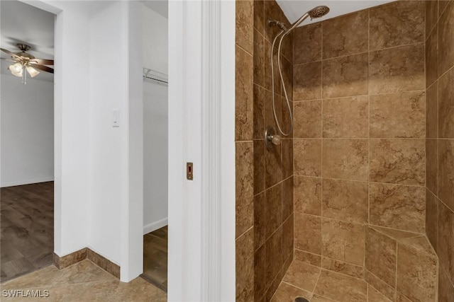 bathroom with ceiling fan and tiled shower