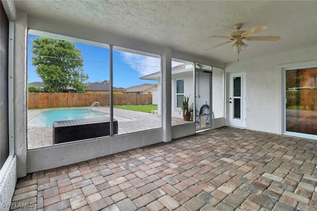 unfurnished sunroom featuring ceiling fan