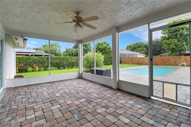 unfurnished sunroom with ceiling fan