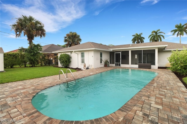 view of pool featuring a sunroom, a lawn, and a patio