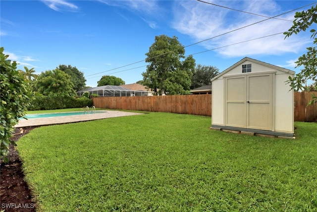 view of yard featuring a storage unit and a fenced in pool