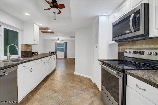 kitchen featuring appliances with stainless steel finishes, ceiling fan, decorative backsplash, and sink