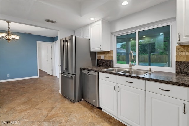 kitchen with backsplash, stainless steel appliances, sink, white cabinetry, and a chandelier