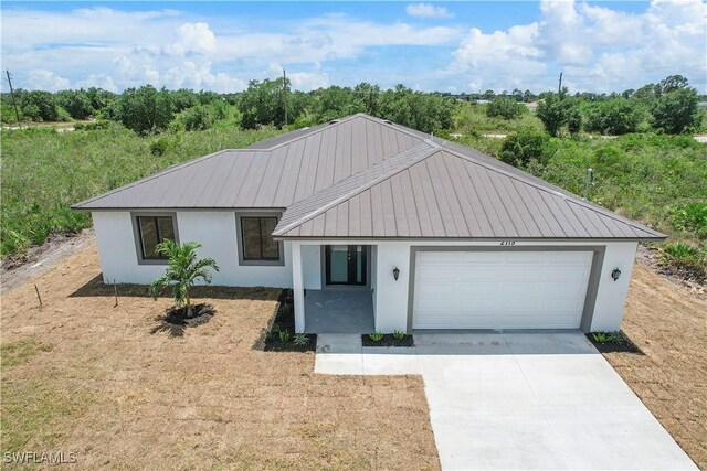 516 Kilarney Ave S, Lehigh Acres, FL 33974 - ranch-style house featuring a garage, stucco siding, driveway, and metal roof
