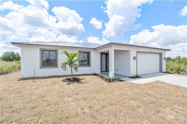 516 Kilarney Ave S, Lehigh Acres, FL 33974 - ranch-style house with an attached garage, stucco siding, a standing seam roof, driveway, and metal roof