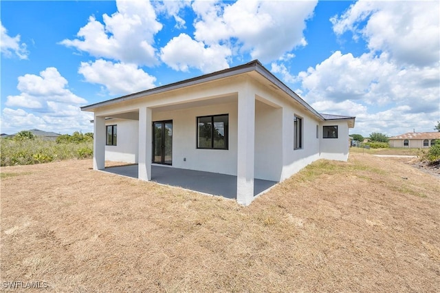 516 Kilarney Ave S, Lehigh Acres, FL 33974 - back of property featuring stucco siding and a patio area