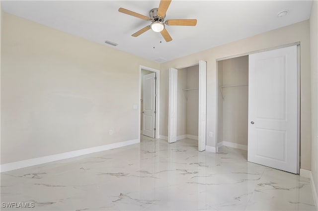 unfurnished bedroom featuring multiple closets and ceiling fan