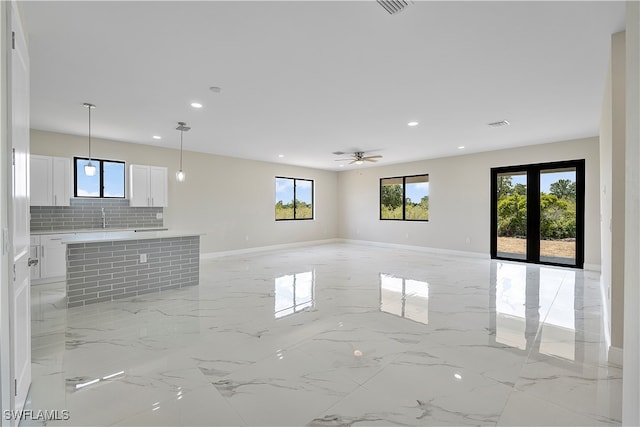 unfurnished living room featuring ceiling fan and sink