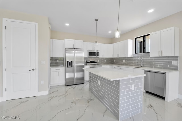 kitchen featuring stainless steel appliances, pendant lighting, a kitchen island, and white cabinets