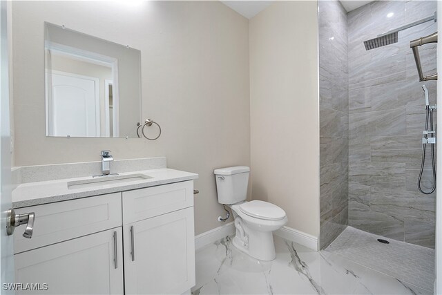 bathroom featuring vanity, toilet, and tiled shower