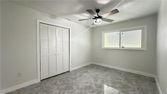 unfurnished bedroom featuring ceiling fan and a closet