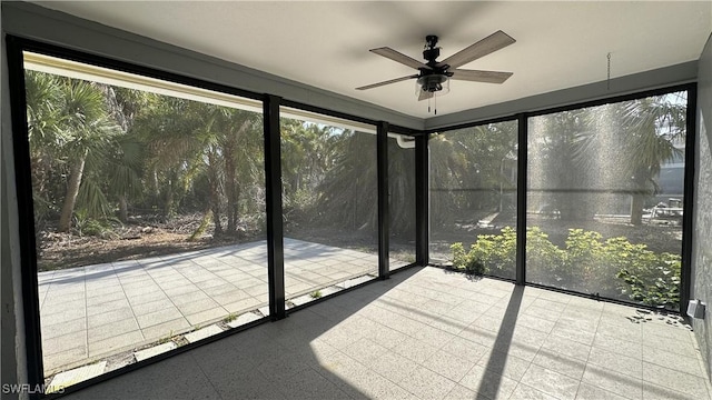 unfurnished sunroom with ceiling fan