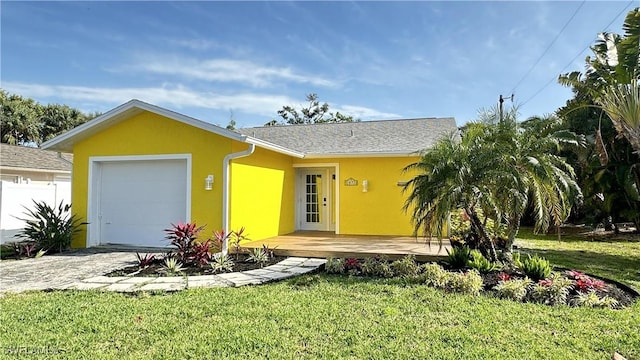 ranch-style home with a garage and a front lawn