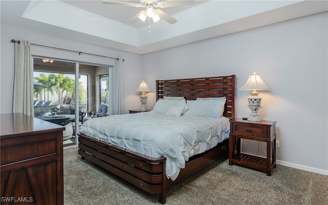 bedroom with ceiling fan, a raised ceiling, carpet, and access to outside