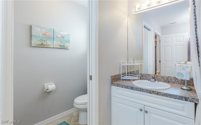 bathroom featuring tile patterned flooring, vanity, and toilet