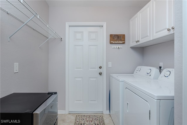 washroom featuring cabinets, washer and dryer, and light tile patterned floors