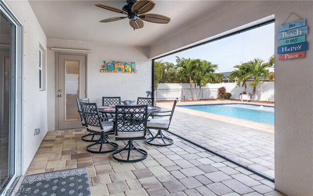 view of swimming pool with ceiling fan and a patio