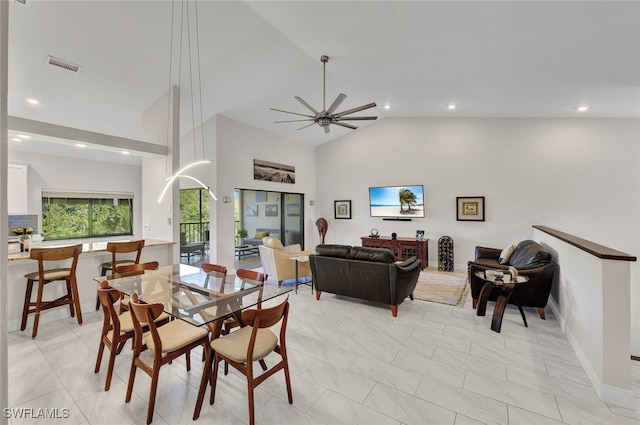 dining space with ceiling fan and high vaulted ceiling