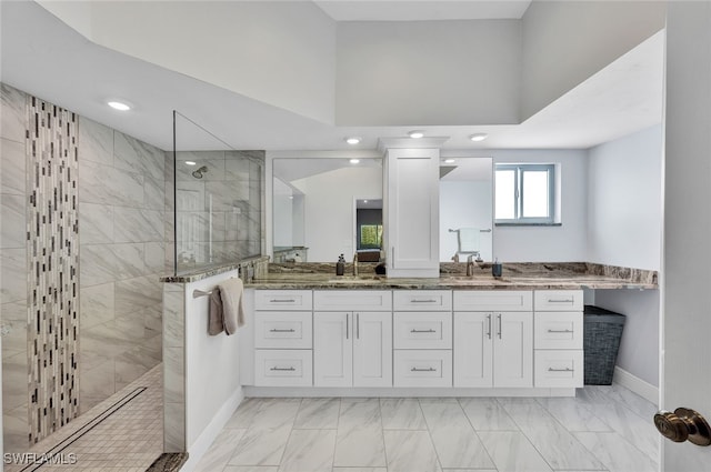 full bath featuring marble finish floor, double vanity, a sink, baseboards, and walk in shower