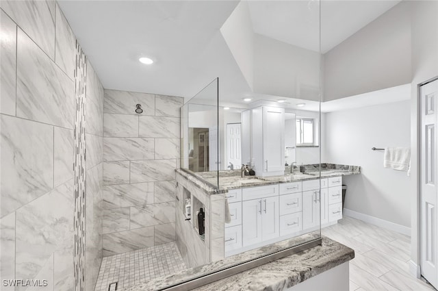 bathroom with a tile shower and vanity