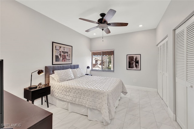 bedroom with marble finish floor, two closets, recessed lighting, ceiling fan, and baseboards