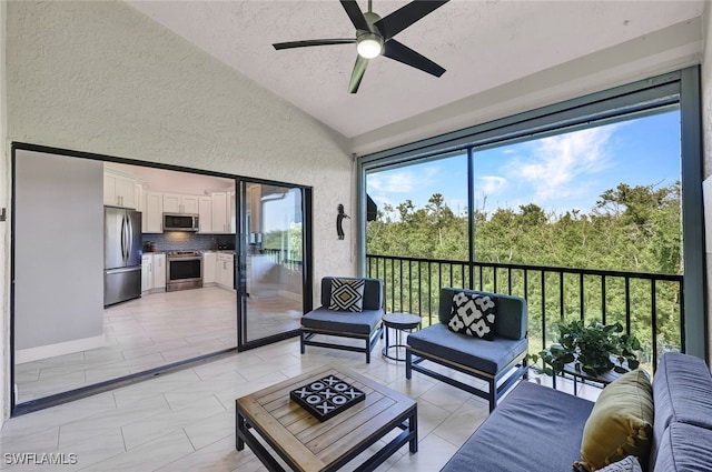 sunroom featuring lofted ceiling and ceiling fan