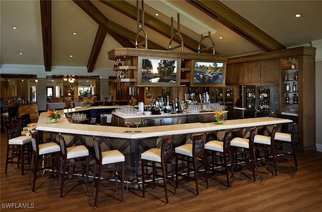 bar with lofted ceiling with beams, wood finished floors, and wet bar