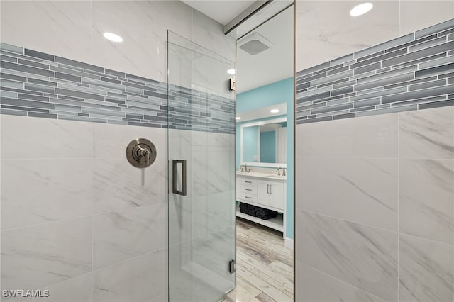 bathroom with vanity, wood-type flooring, and a shower with shower door