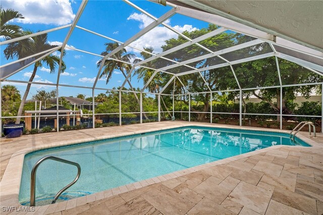 view of swimming pool featuring a patio and a lanai