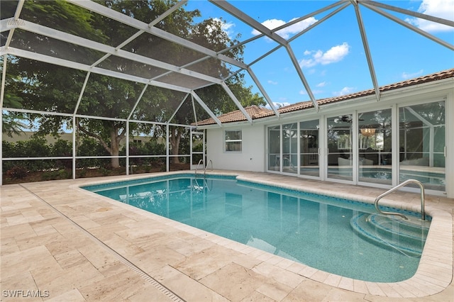 outdoor pool with glass enclosure and a patio