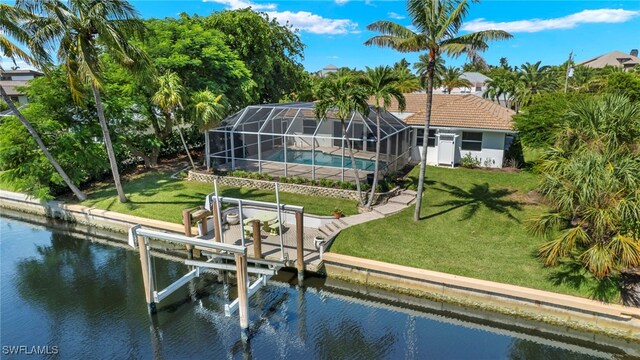 back of house featuring a water view, a yard, and a lanai