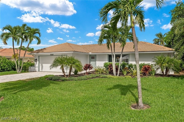 view of front of house featuring a tiled roof, a front yard, stucco siding, decorative driveway, and an attached garage