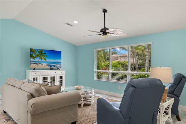 living area with baseboards, lofted ceiling, and wood finished floors