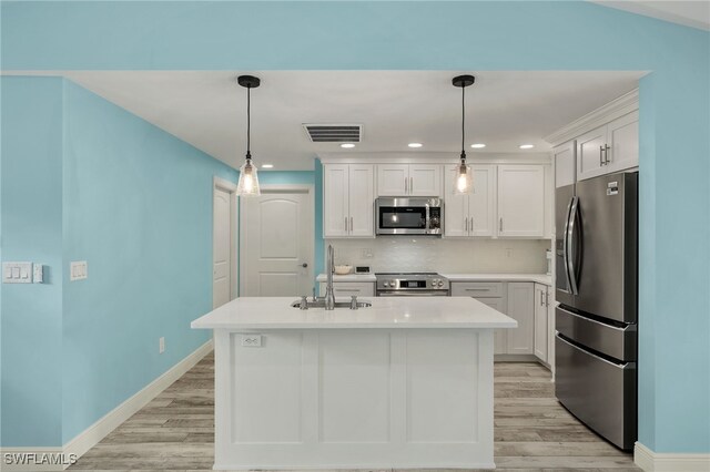 kitchen with white cabinets, light hardwood / wood-style flooring, appliances with stainless steel finishes, sink, and a center island with sink