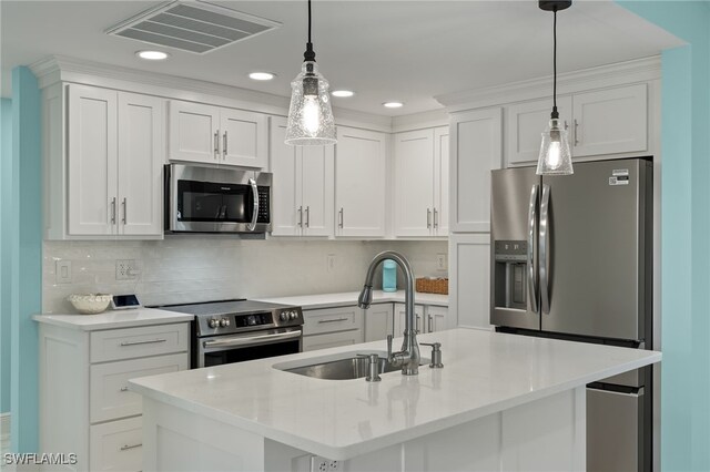 kitchen featuring appliances with stainless steel finishes, decorative backsplash, a center island with sink, and sink