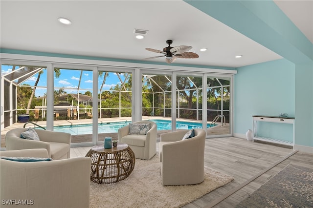 sunroom featuring a pool, visible vents, and ceiling fan