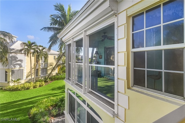 view of home's exterior with ceiling fan and a lawn