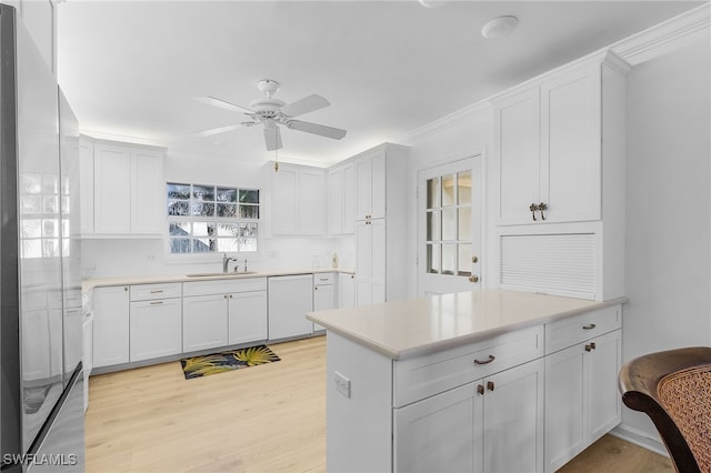 kitchen with sink, white cabinetry, white dishwasher, and stainless steel fridge