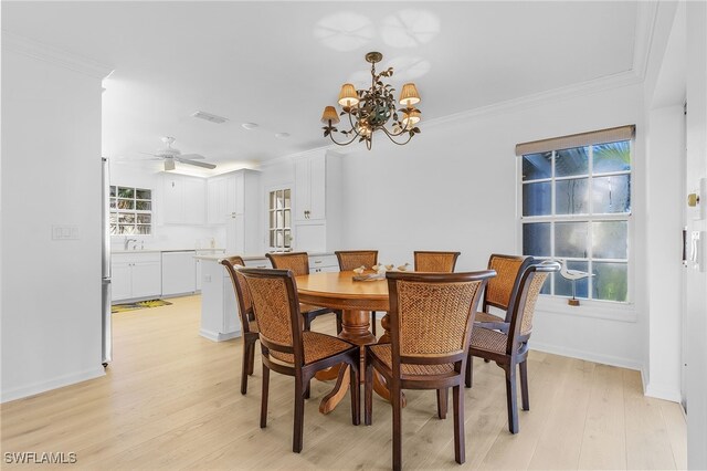 dining room featuring sink, a healthy amount of sunlight, light hardwood / wood-style flooring, and crown molding