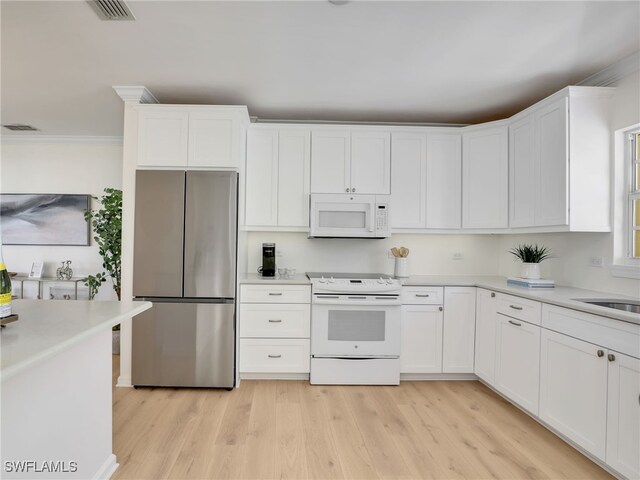 2601 Gulf Shore Blvd N Unit 34, Naples, FL 34103 - kitchen featuring white appliances, light wood finished floors, white cabinets, light countertops, and crown molding