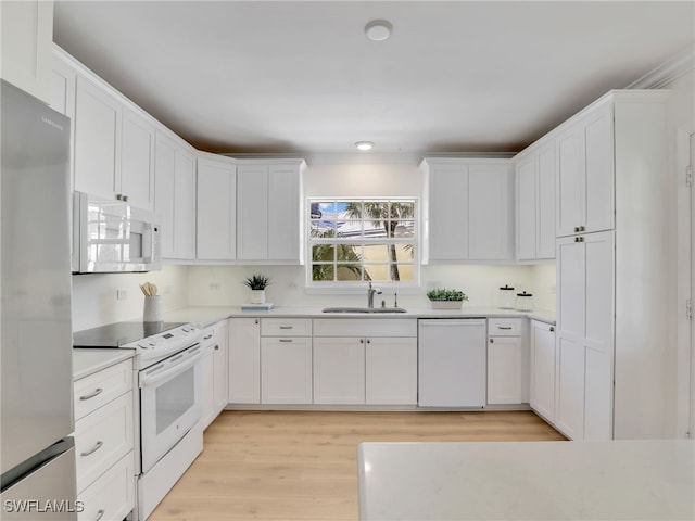 2601 Gulf Shore Blvd N Unit 34, Naples, FL 34103 - kitchen with white appliances, white cabinetry, light countertops, and light wood-style floors
