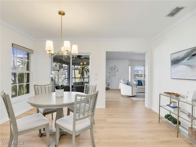 2601 Gulf Shore Blvd N Unit 34, Naples, FL 34103 - dining area featuring a chandelier, ornamental molding, healthy amount of natural light, and light wood finished floors