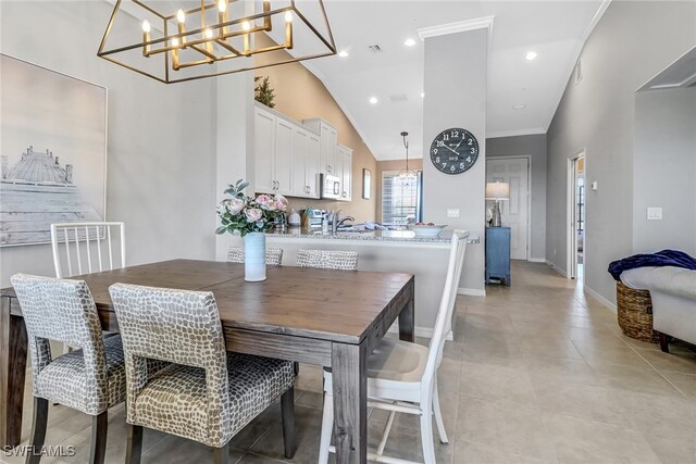 dining room with high vaulted ceiling, crown molding, a chandelier, and light tile patterned floors