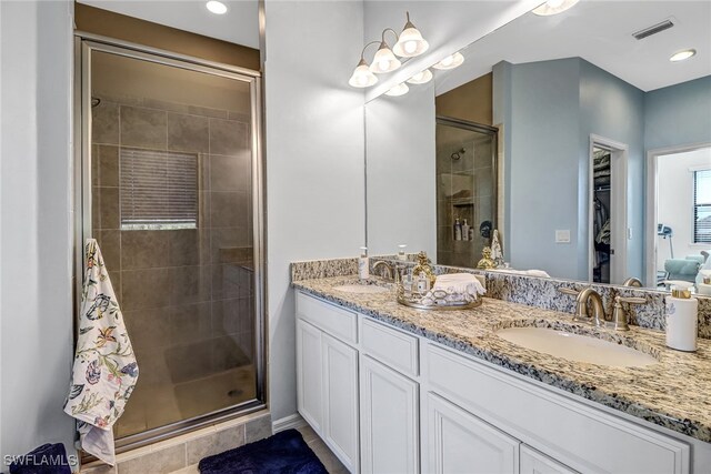 bathroom featuring tile patterned floors, an enclosed shower, and vanity