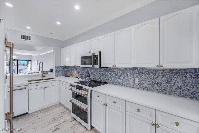 kitchen with light wood-type flooring, dishwasher, sink, white cabinetry, and double oven range