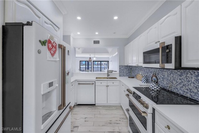 kitchen with sink, white cabinets, light hardwood / wood-style flooring, stainless steel appliances, and decorative backsplash