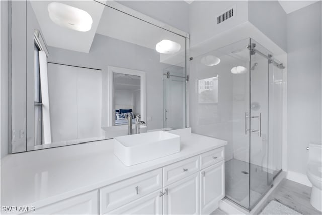 bathroom featuring walk in shower, vanity, and toilet