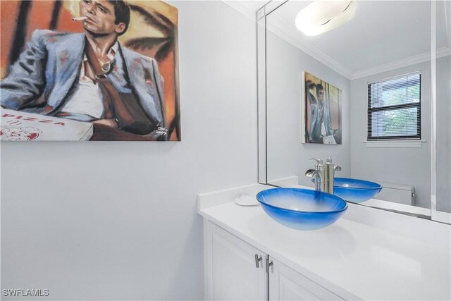 bathroom featuring vanity, crown molding, and toilet