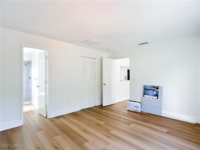 unfurnished bedroom with a closet and light wood-type flooring